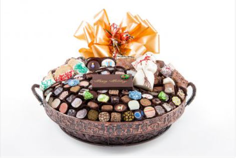 Exotic Bronze vessel with 105 pc of chocos, white chocolate snowman & foil cvrd snowflakes & trees
